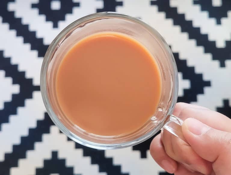 hand holding a hong kong style milk tea in the air