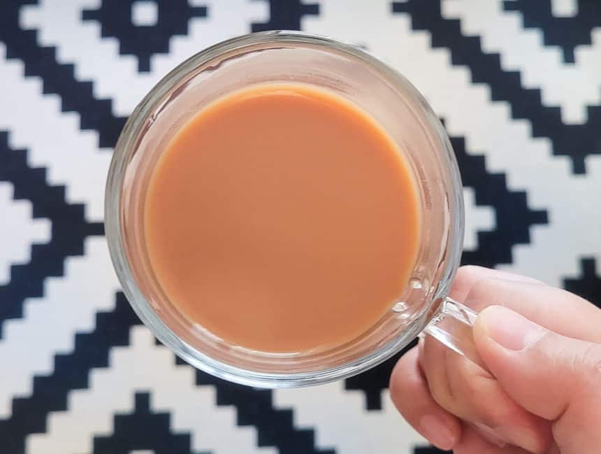 hand holding a hong kong style milk tea in the air
