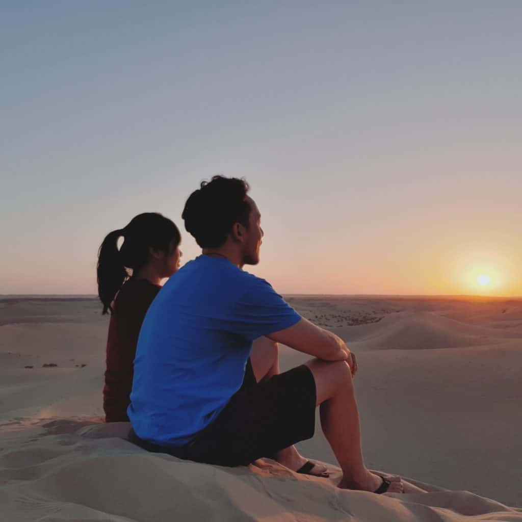 two people looking at the sunset in the Abu Dhabi dessert