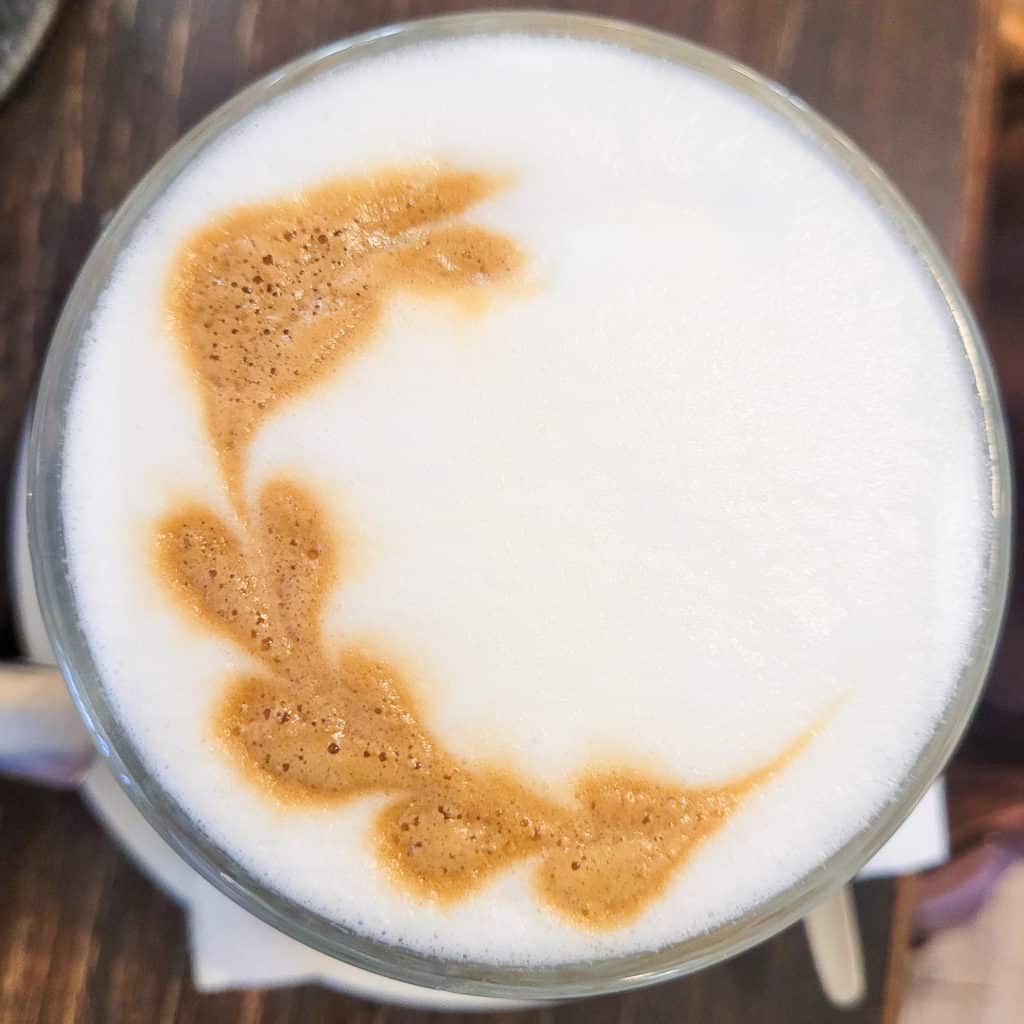 A overhead view of latte art with heart designs going along the curve of a mug