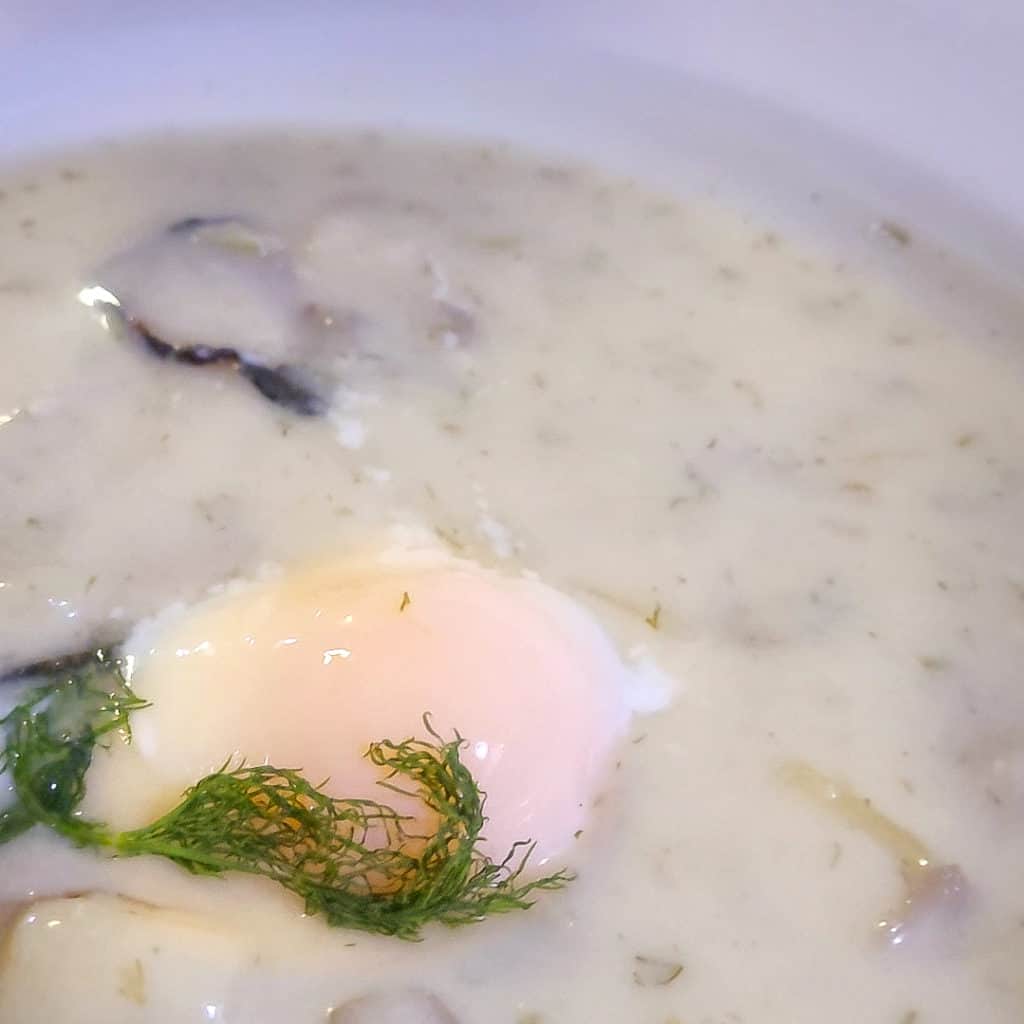 Kulajda soup with a soft-boiled egg in the middle of a soup bowl
