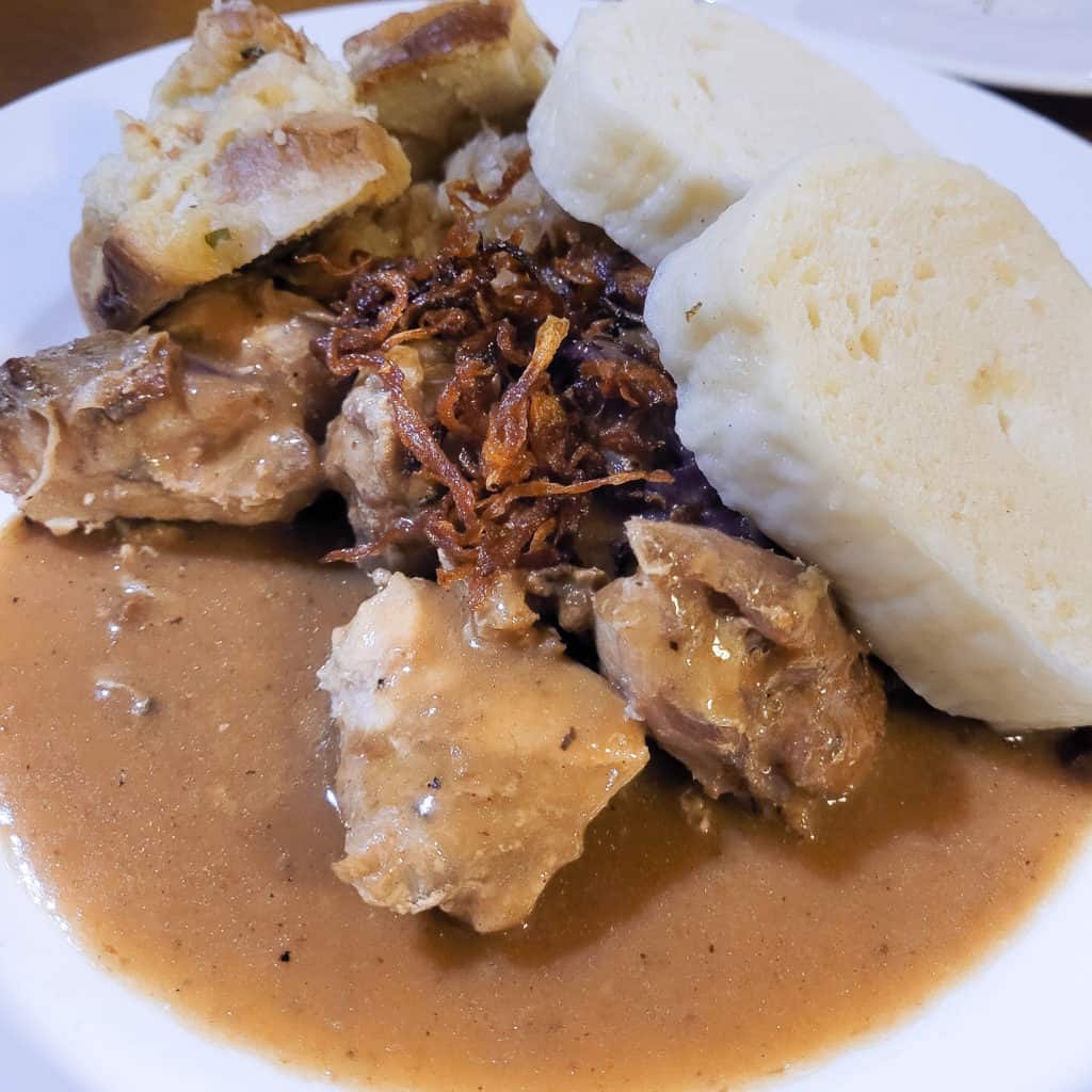 A dish of stewed pork with crispy onions and bread dumplings