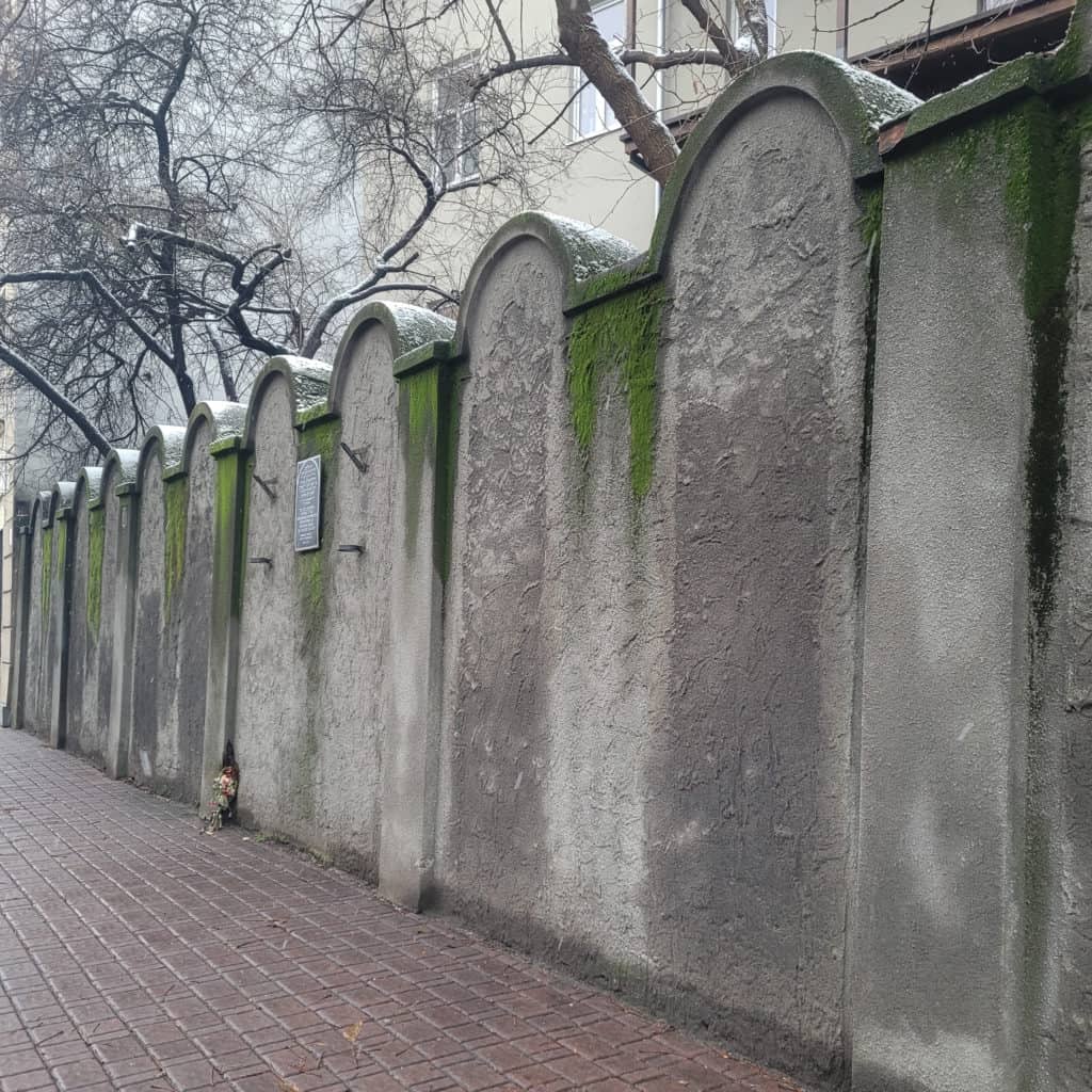 The remnant of a Jewish ghetto wall in Krakow Poland in winter with trees in the background
