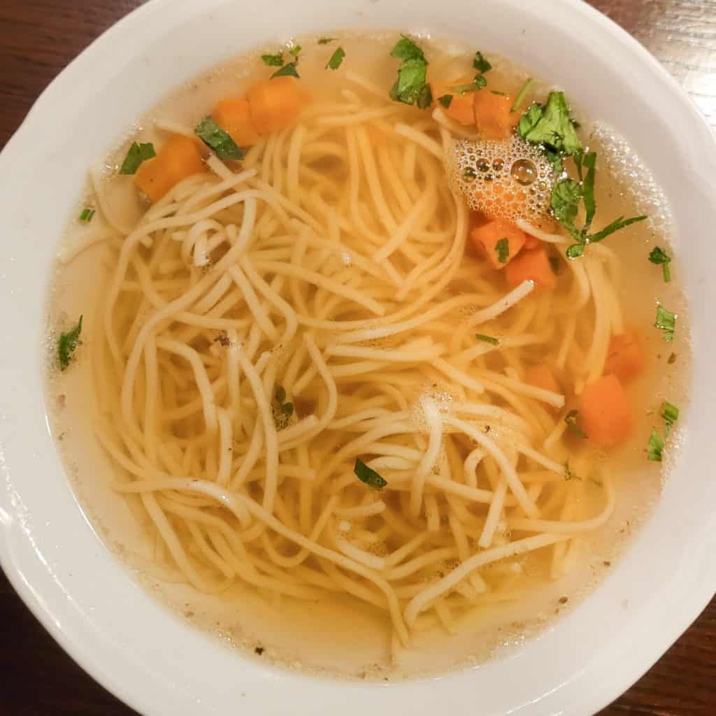 Chicken noodle soup overhead shot in a white bowl