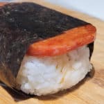 Closeup of an unwrapped musubi on a cutting board