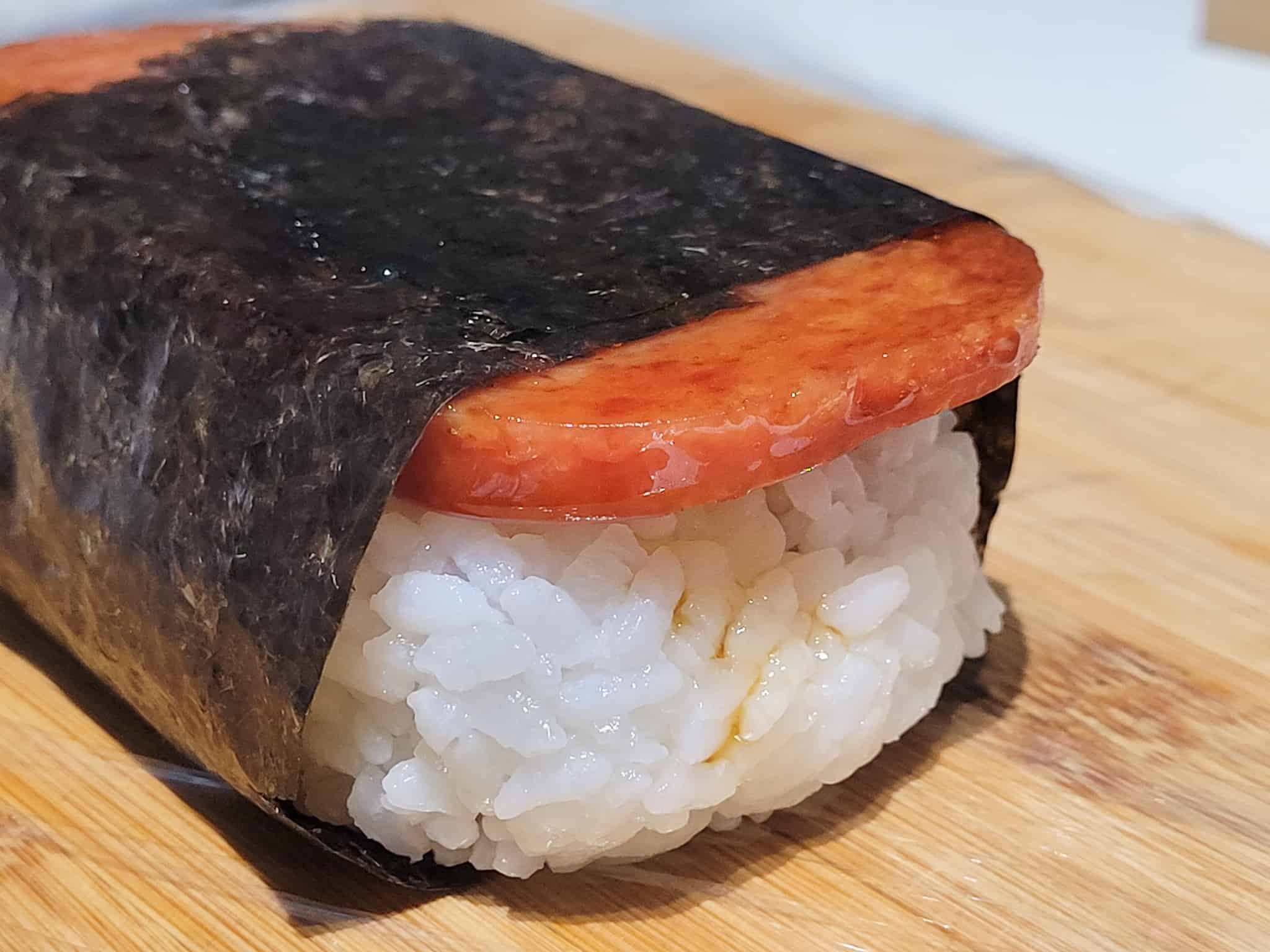Closeup of an unwrapped musubi on a cutting board