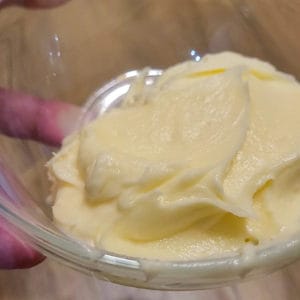 A small glass bowl with buttercream in it
