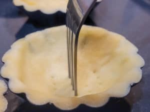 Yema tart dough in tin docked with fork