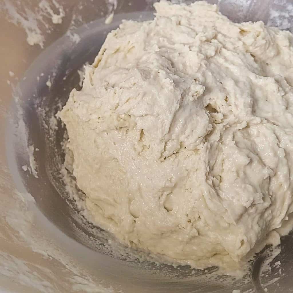 Close up of yeasted dough in a clear bowl