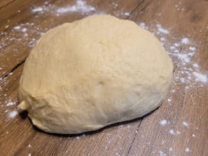 Closeup of raw dough on a floured wooden surface