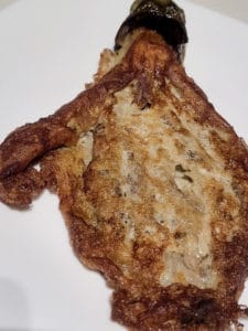 Fried eggplant with egg on a white plate
