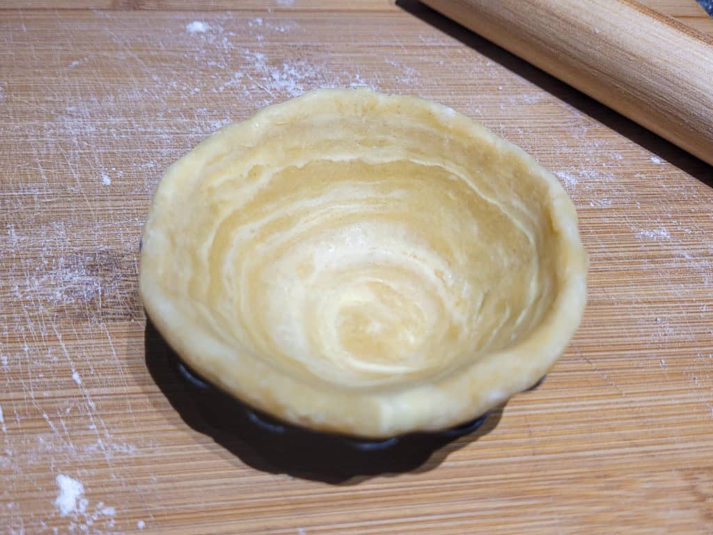 Pastry dough fitted into a metal tart mold