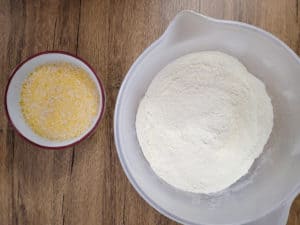 Bowl of butter and milk next to a bigger bowl of flour