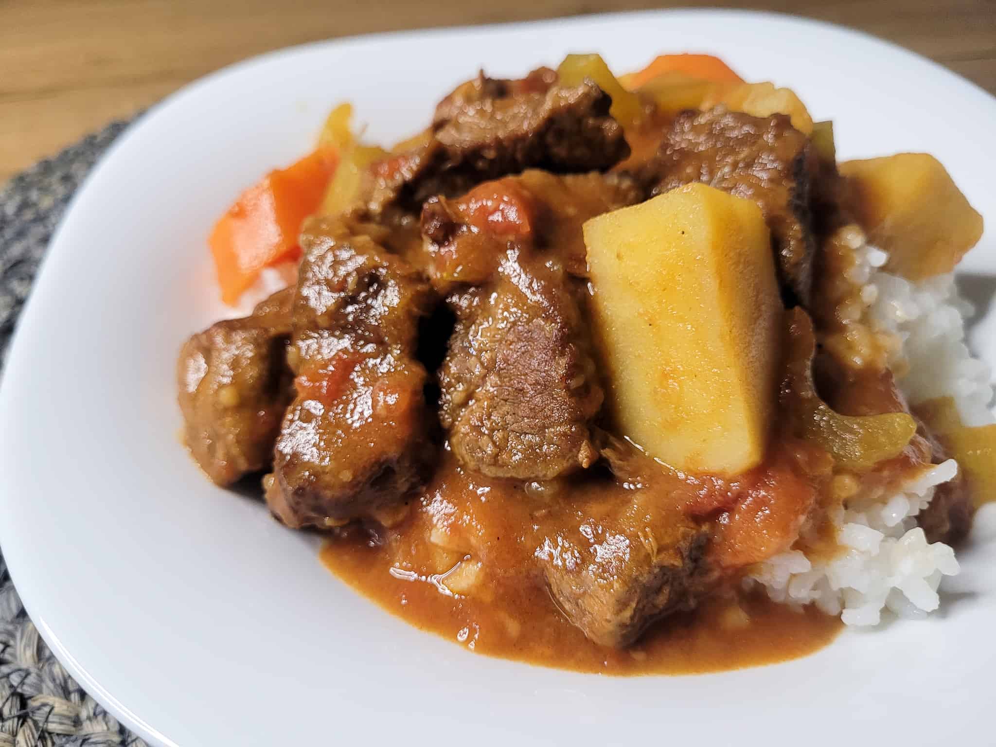 local style beef stew made with potatoes, tomatoes, celery and carrots on a plate