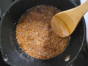 Latik cooking in progress in a black pot