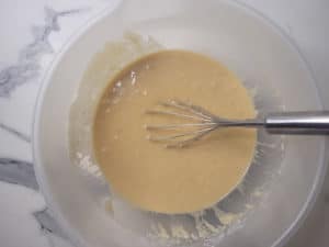 Bowl of mixed ingredients with a silver whisk