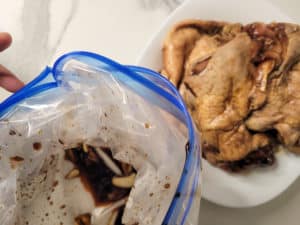 Removing chicken from plastic bag on a counter