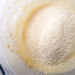 Desiccated coconut on top of batter in a bowl