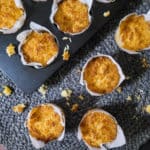 Scattered Filipino-style coconut macaroons on a round blue table mat on top of wooden table