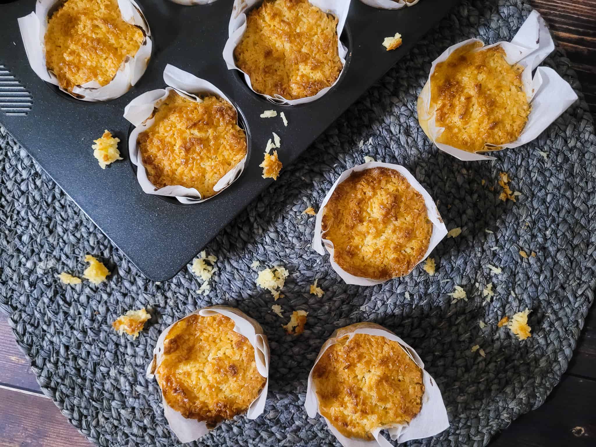 Scattered Filipino-style coconut macaroons on a round blue table mat on top of wooden table