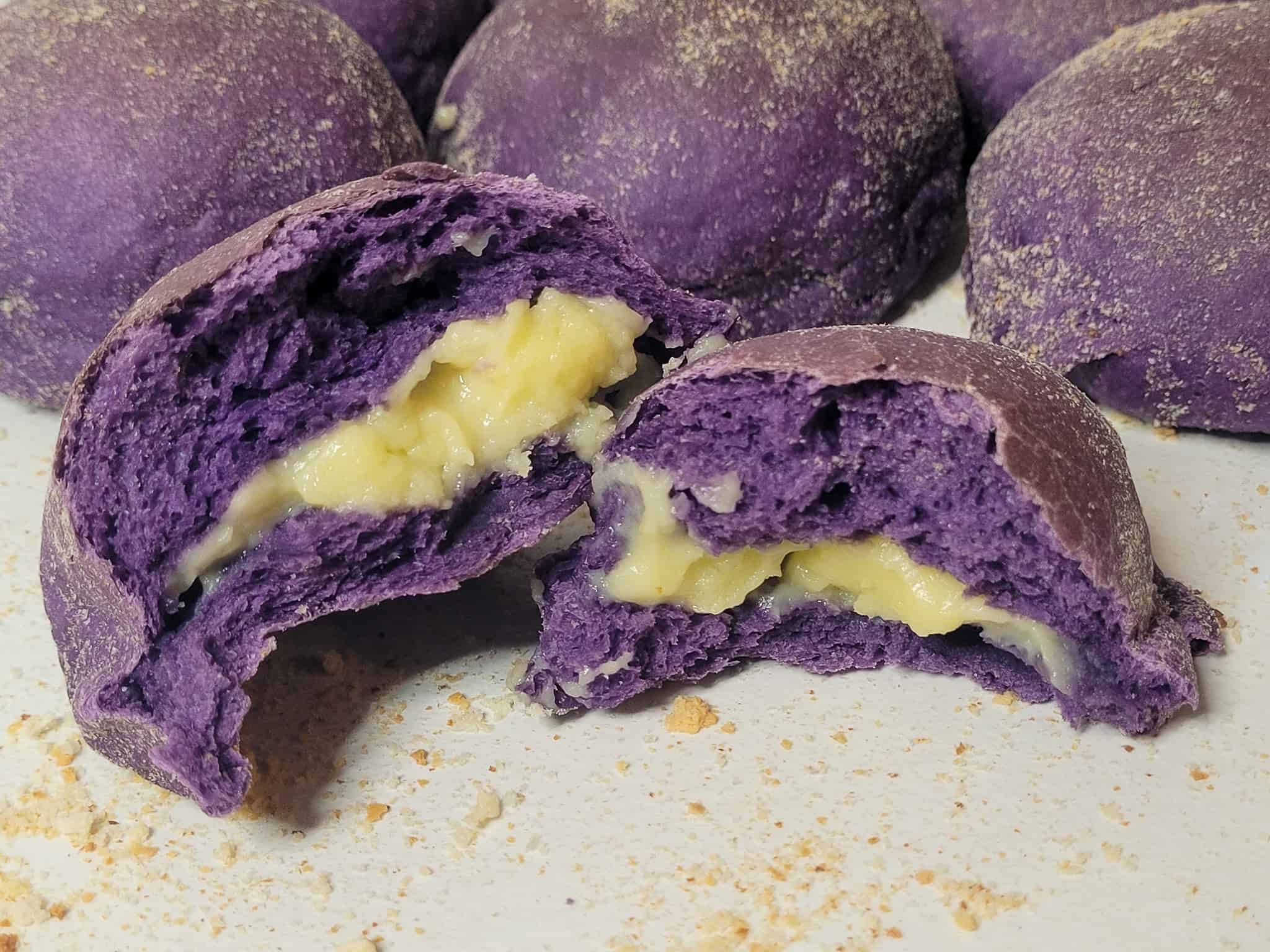 Cross section of ube pandesal in front of other buns