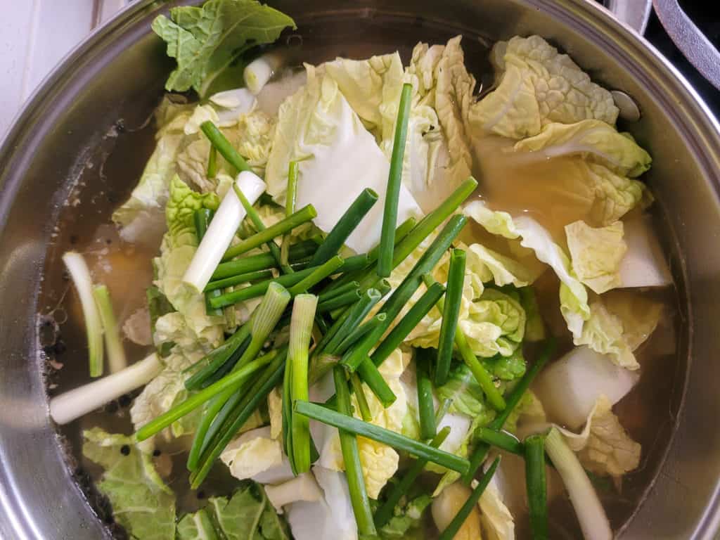 Overhead shot of vegetables in a pot of bulalo