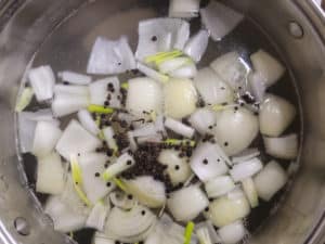 Onions and black peppercorns in a pot of water for nilaga