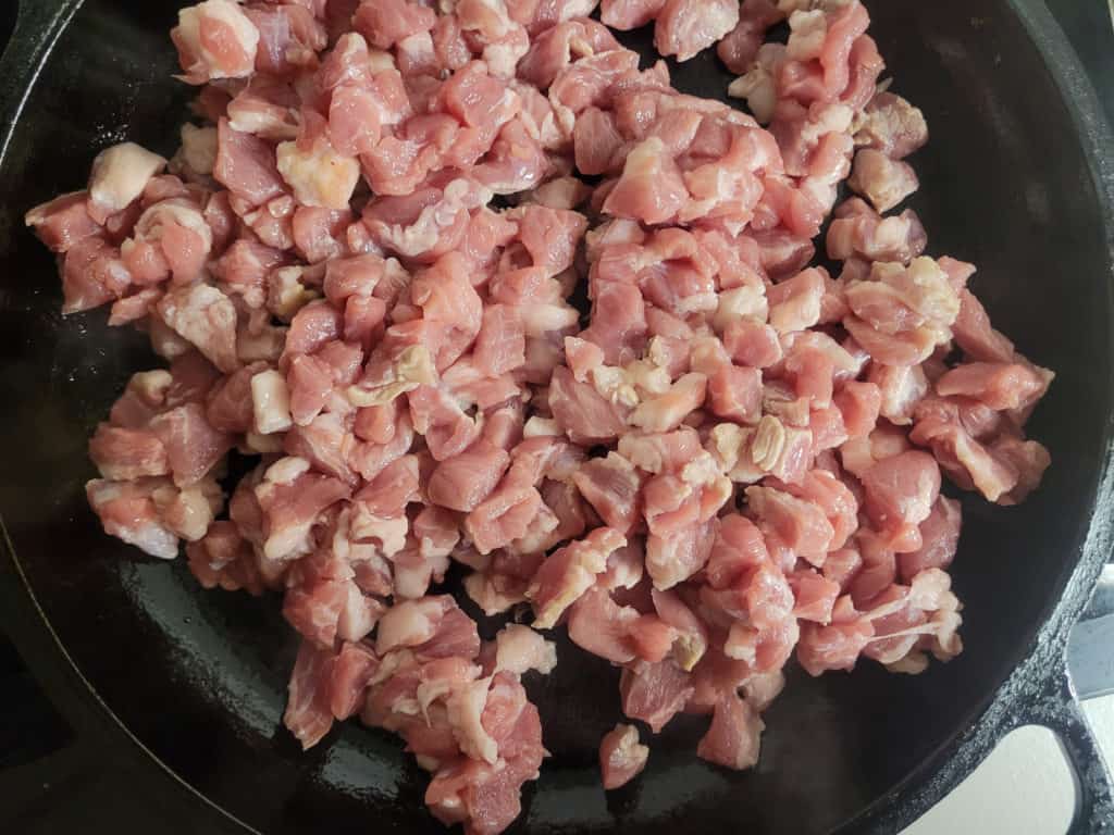 Pork being cooked in a cast iron
