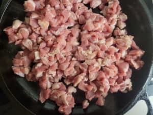 Pork being cooked in a cast iron