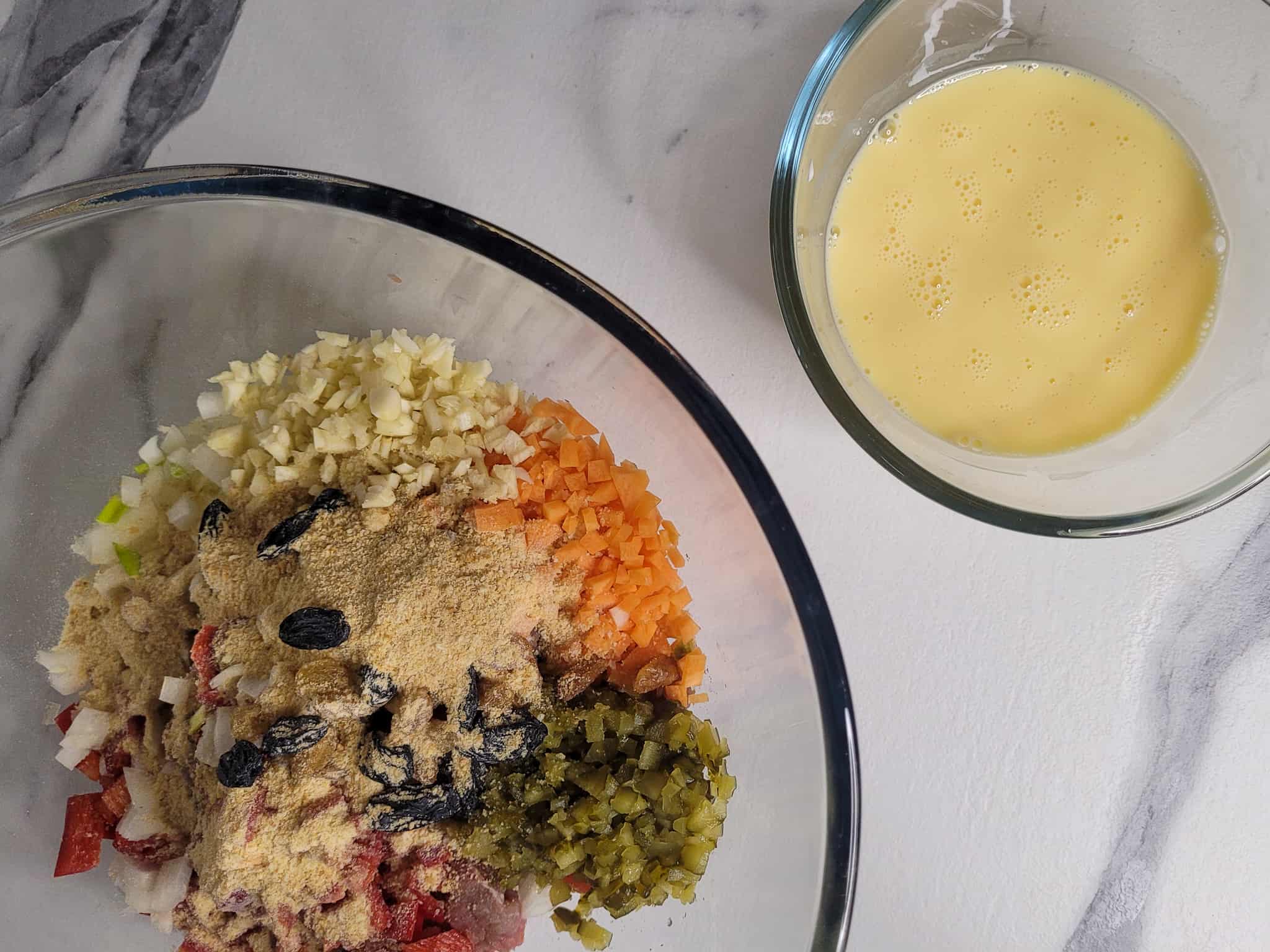 Bowl of dry ingredients next to a small bowl with beaten eggs