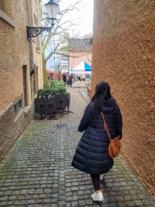 Back of a woman walking through an alleyway
