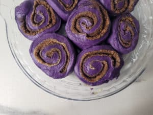 Closeup of ube rolls in a buttered pan