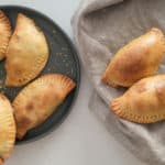 Empanadas on a gray plate next to empanadas on a towel