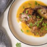 Cast iron chicken thigh with gravy in a plate