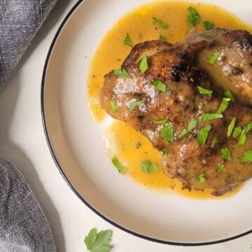 Cast iron chicken thigh with gravy in a plate