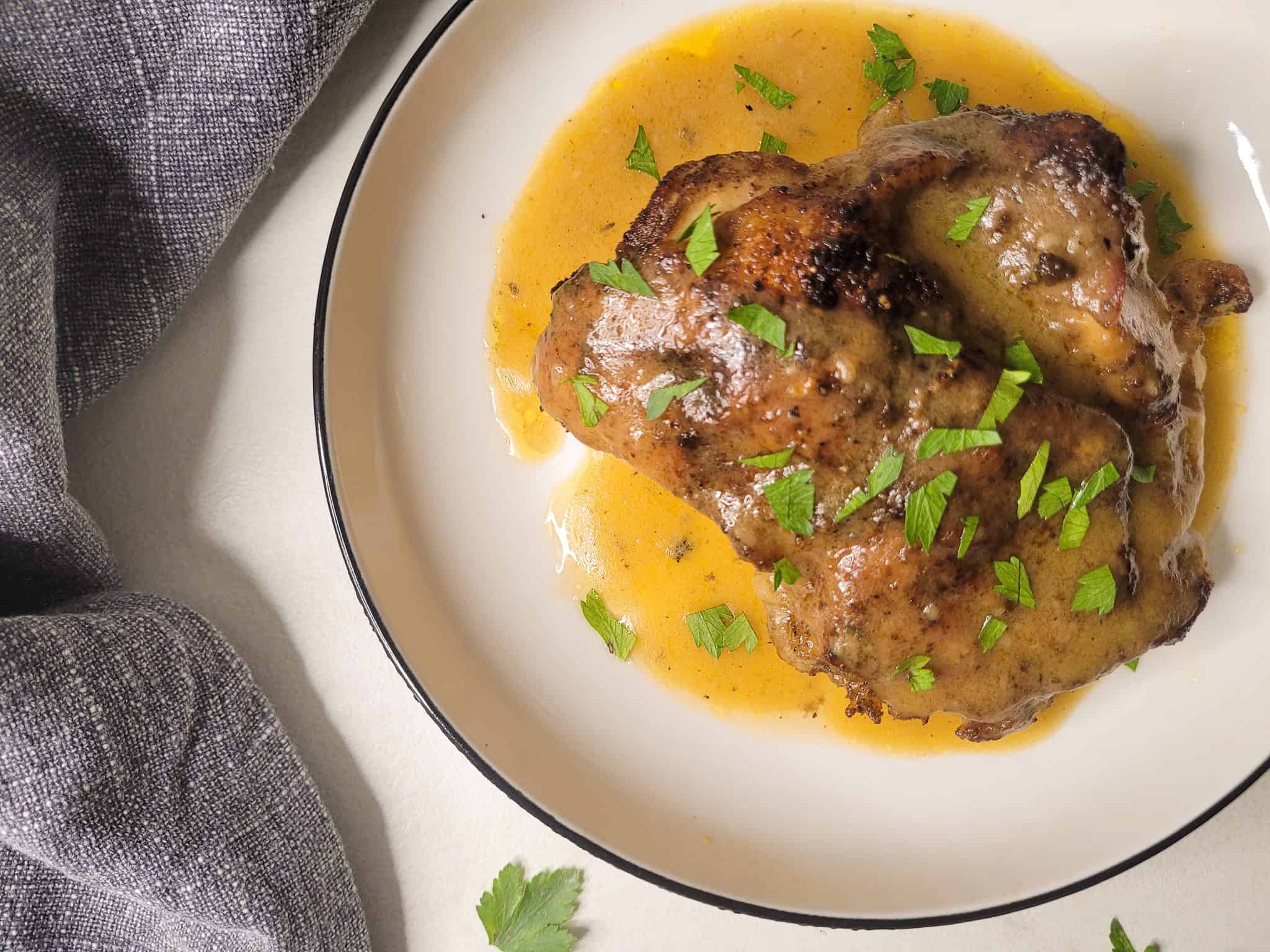 Cast iron chicken thigh with gravy in a plate