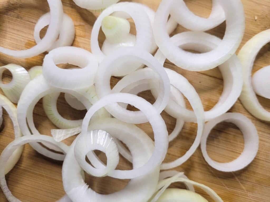 Raw onion rings on a cutting board