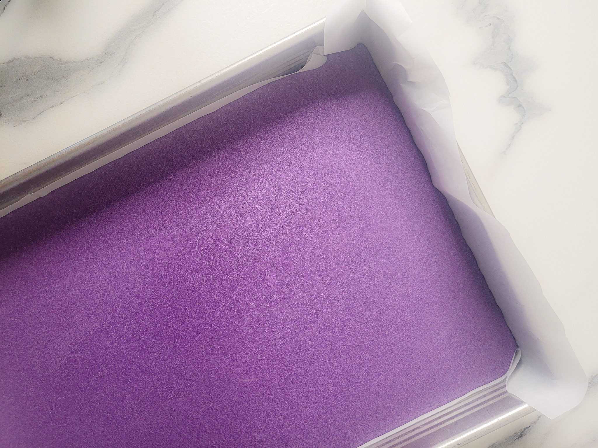 Raw ube butter mochi batter in a pan
