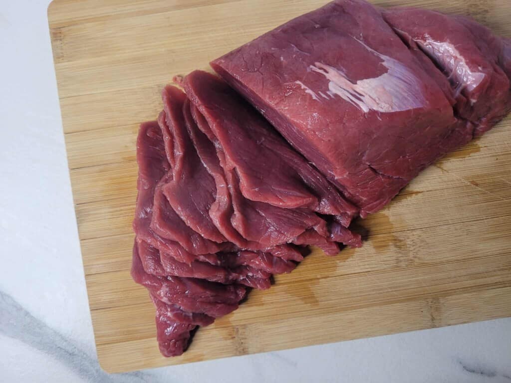 Sliced raw beef on a cutting board