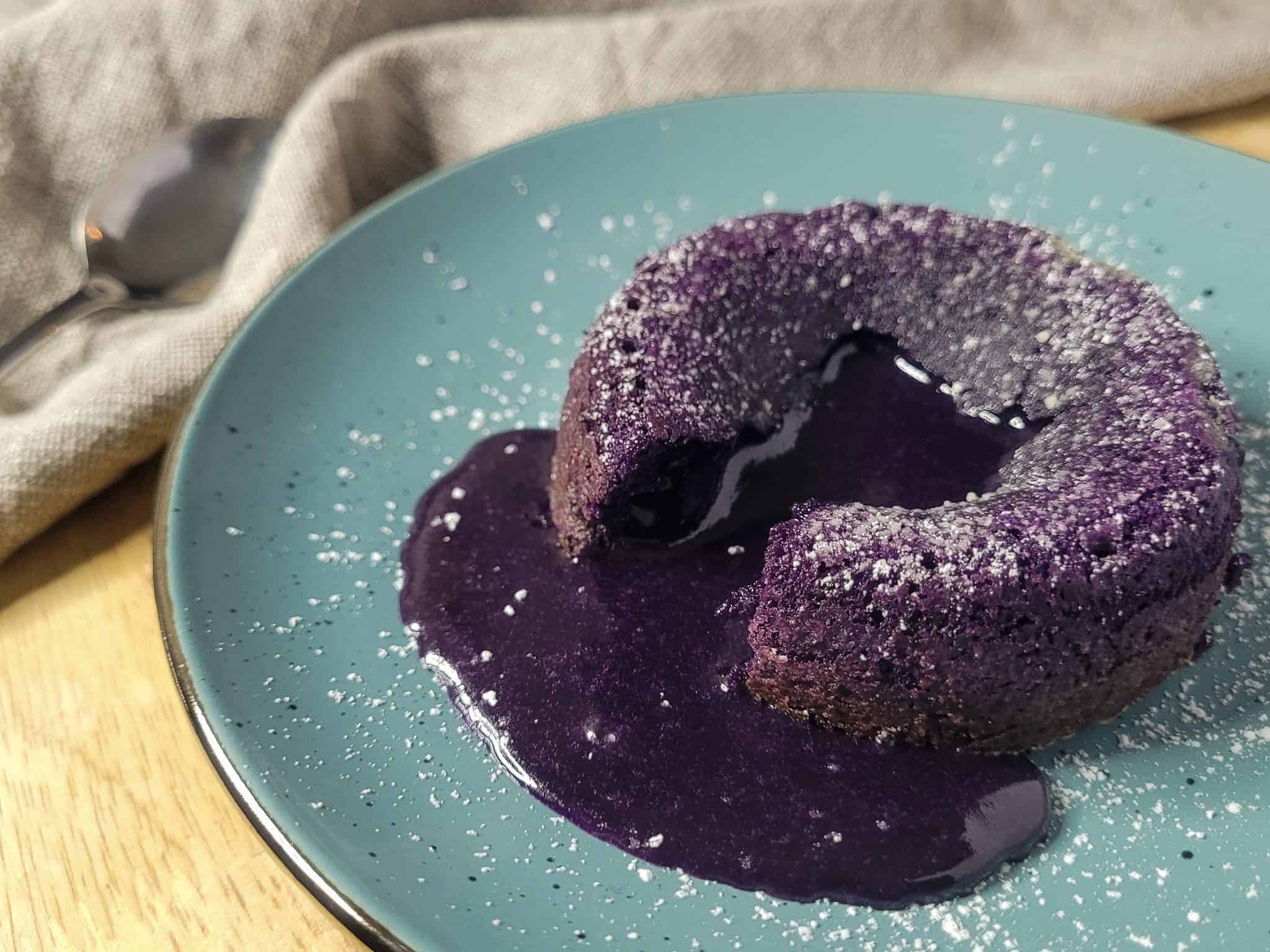 Closeup of ube lava cake on a blue plate