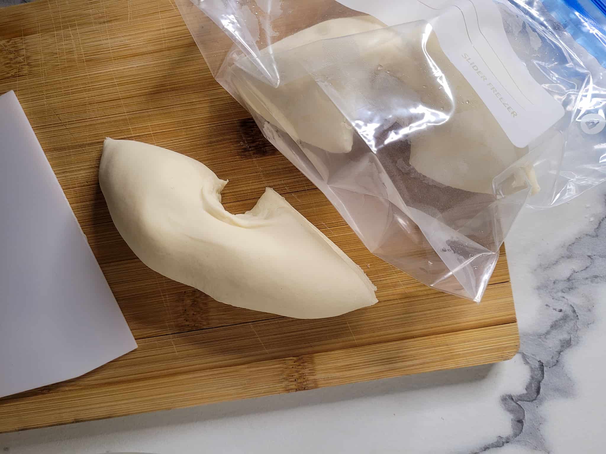 Two pieces of dough on a wooden board
