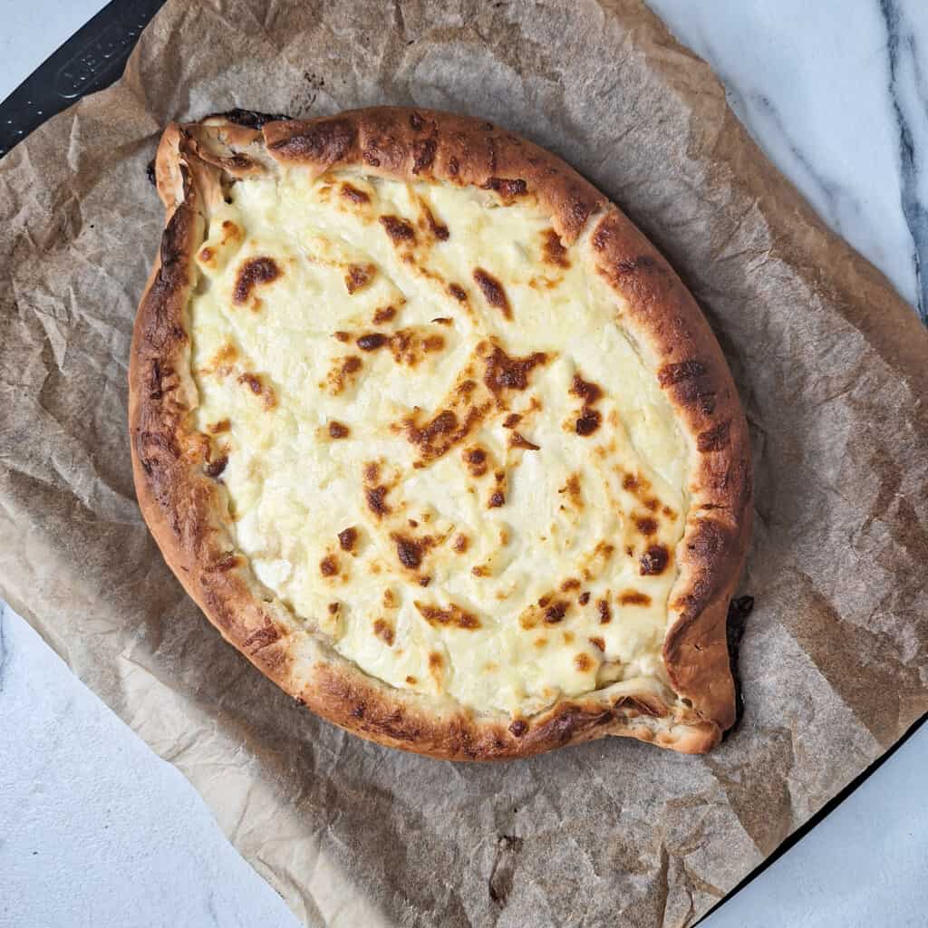 A bread shaped like a boat that has toasted cheese filling in the middle also known as Adjarian khachapuri