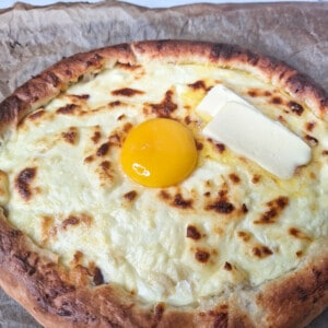 Adjarian khachapuri also known as Georgian Cheese boat bread with an egg in the middle and slices of butter