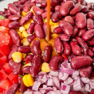 Pouring vinaigrette on top of beans