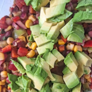 Sliced avocados on top of diced vegetable salad