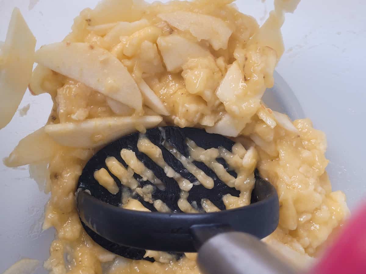 Mashed bananas and apples in a clear bowl