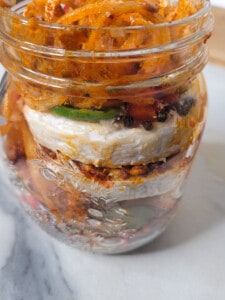Jar with cheese and marinated vegetables