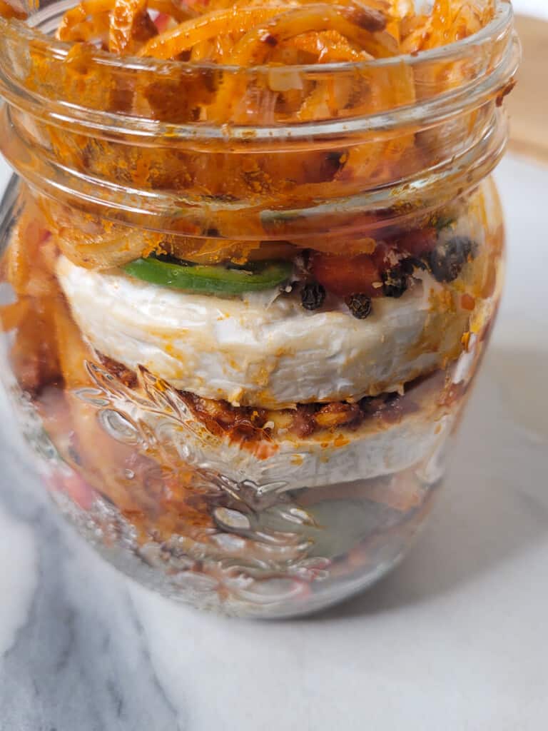 Jar with cheese and marinated vegetables