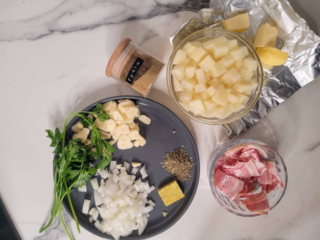 Sliced onions, garlic, parsley, potatoes and other ingredients on a marble countertop