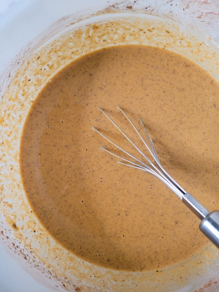 Mixed pumpkin crunch cake filling in a plastic bowl